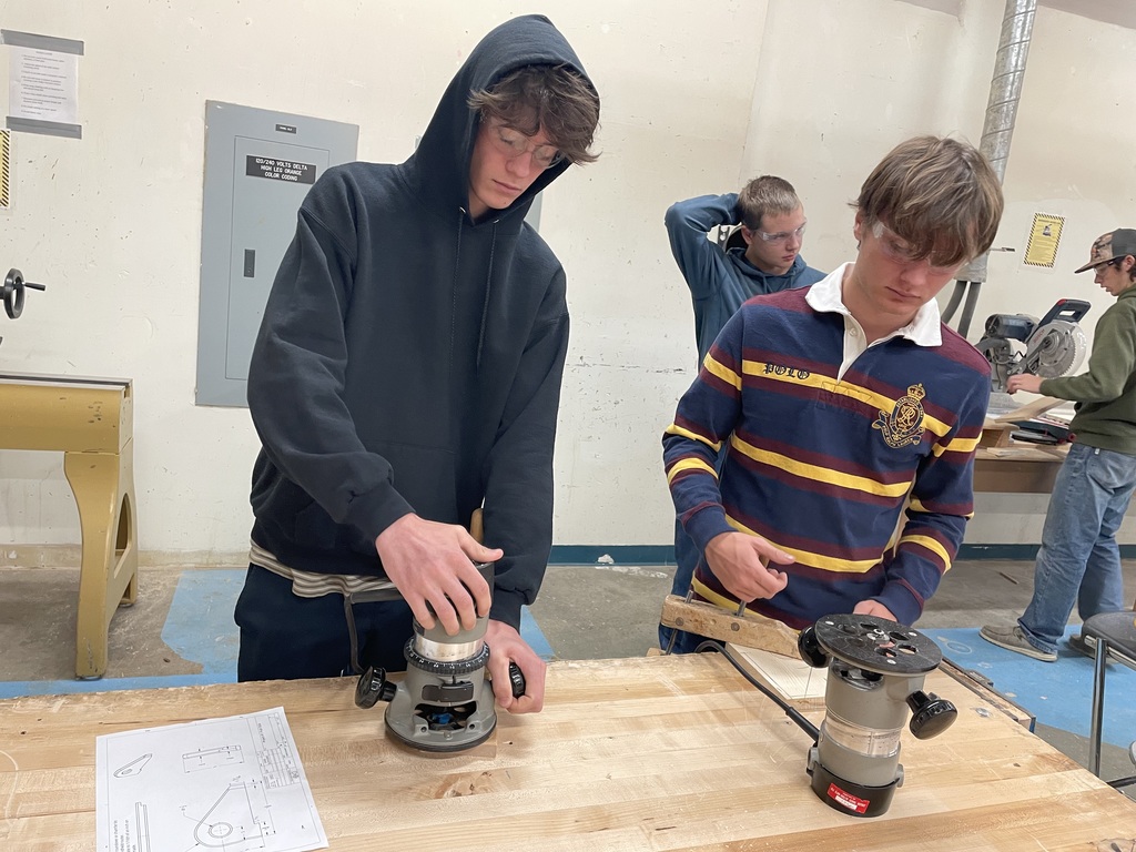 Shop students using a hand tool