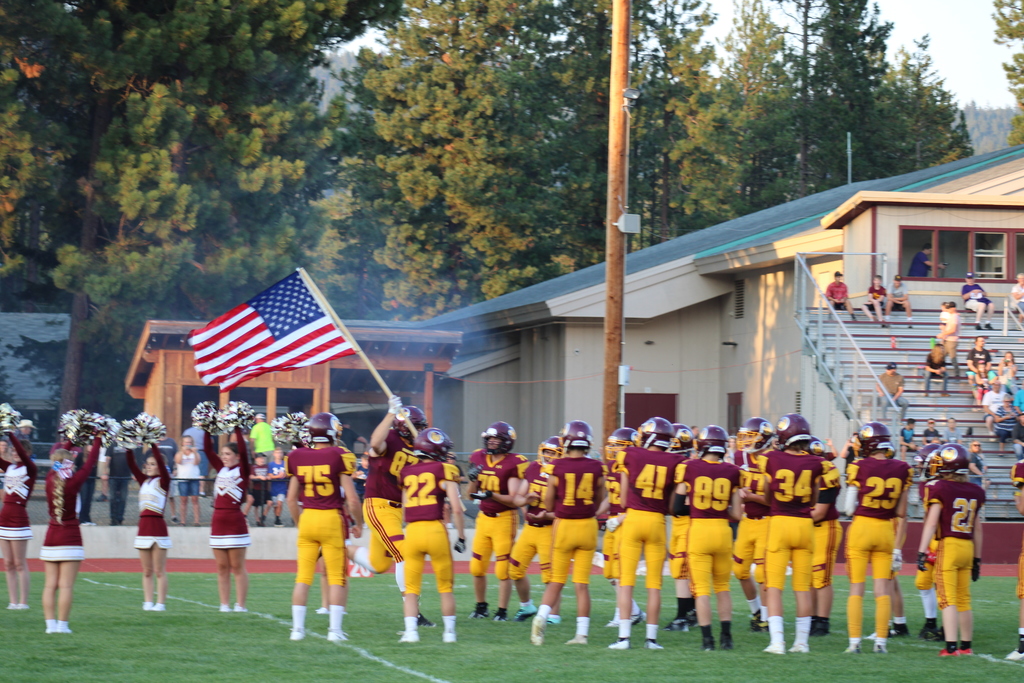 football players running the flag into the field