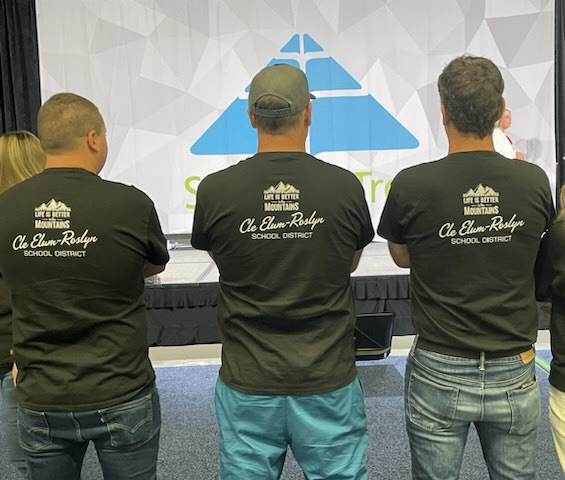 Superintendent Belcher with Mr. Chase and Mr. Van with their backs to the camera to show their district tshirts that read Life is better in the Mountains 